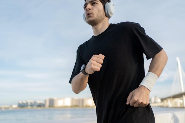 Running in sportswear and headphones A male runner trains outside