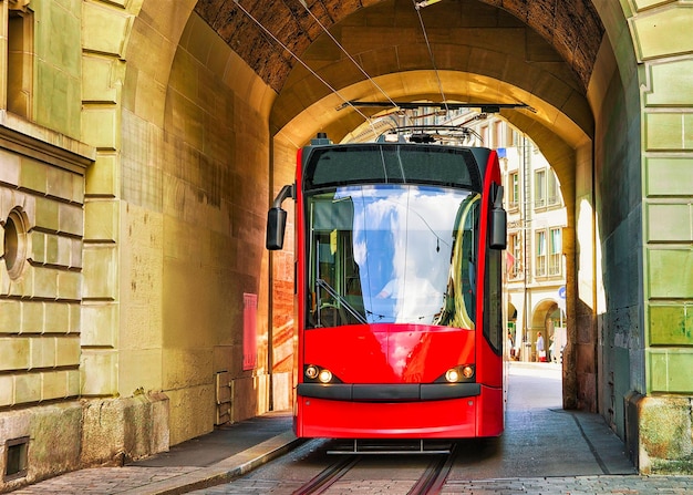 Running tram at the gate on Kramgasse street in old city center of Bern, Switzerland