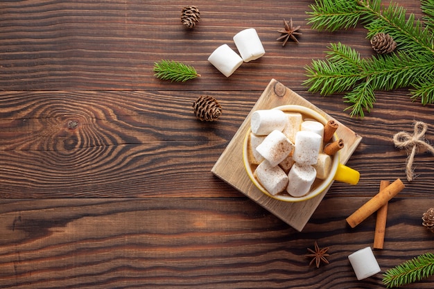 Rural Christmas composition with a mug of coffee and marshmallows on wooden table