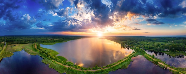 Rural summer sunset landscape with river and dramatic colorful sky natural background aerial panoramic view