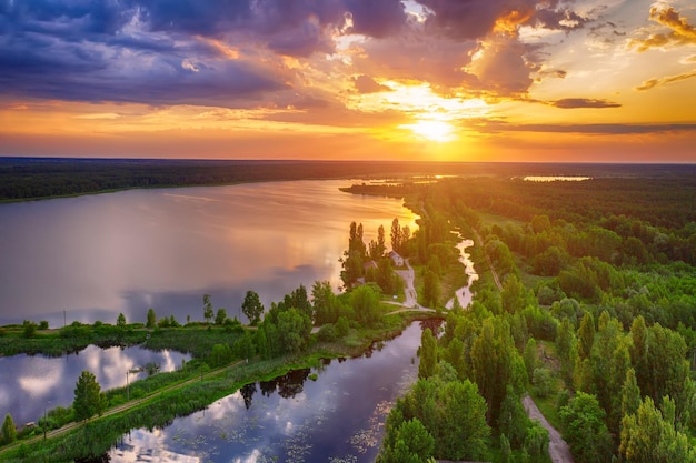 Rural summer sunset landscape with river and dramatic colorful sky natural background aerial view