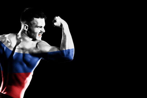 Russia flag on handsome young muscular man black background