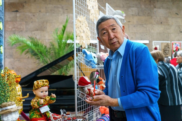 Russia, Gatchina, October 14, 2022 An elderly Asian man at a handmade exhibition