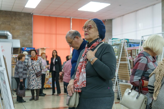 Russia, Gatchina, October 14, 2022 An elderly woman at a handmade exhibition