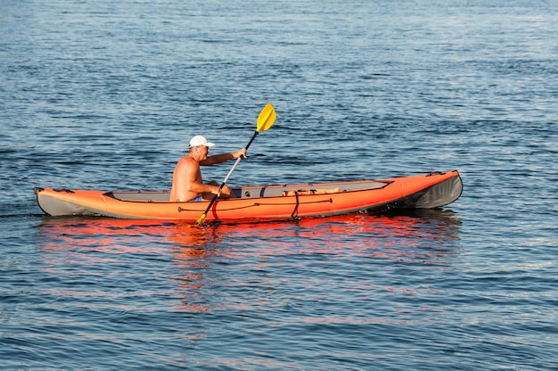 Russia St Petersburg June 2022 A man with a bare torso controls a kayak on the river