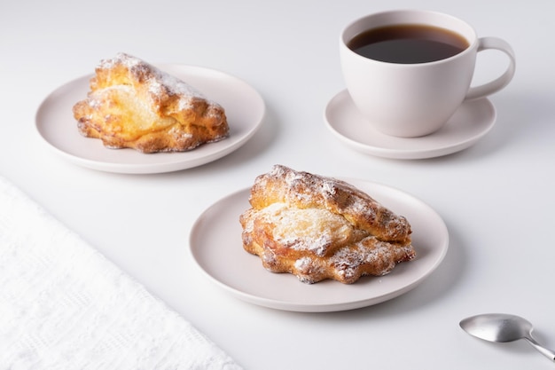 Russian baking with cottage cheese Sochniki with cottage cheese on the plate and a cup of coffee