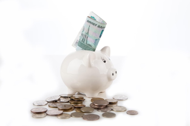 Russian banknotes and coins in the piggy bank on white background