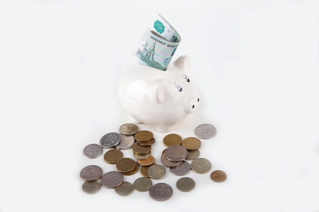 Russian banknotes and coins in the piggy bank on white background