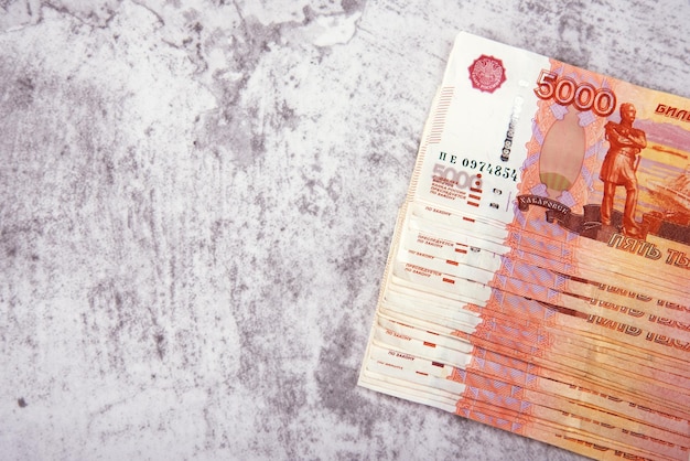 Russian cash banknotes in denominations of five thousand rubles the bundle lies on a gray background