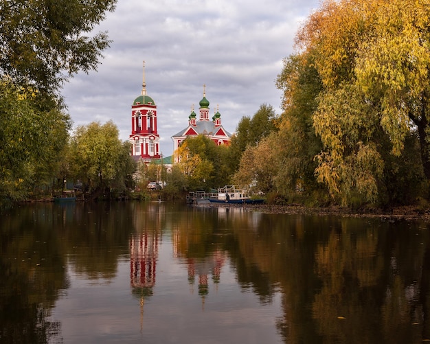 Photo russian church is reflected in pond surrounded by colorful autumn trees pereslavlzalessky russia