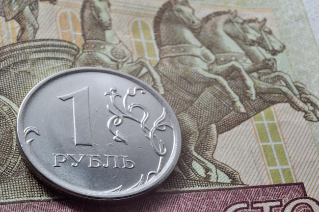 Russian coin with a face value of 1 ruble lies on a banknote Translation of the inscriptions on the coin quot1 rublequot