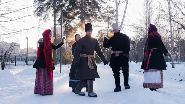 Russian folk  people in felt boots dancing outdoors at winter time