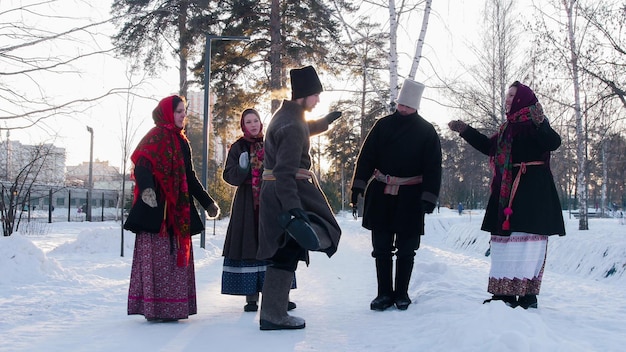 Russian folk  young people in felt boots dancing outdoors at winter time