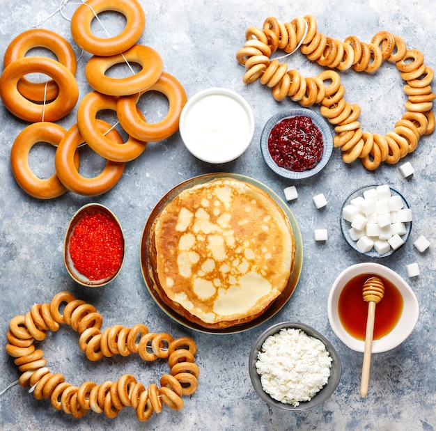 Russian pancake blini with raspberry jam, honey, fresh cream and red caviar, sugar cubes, cottage cheese, bubliks