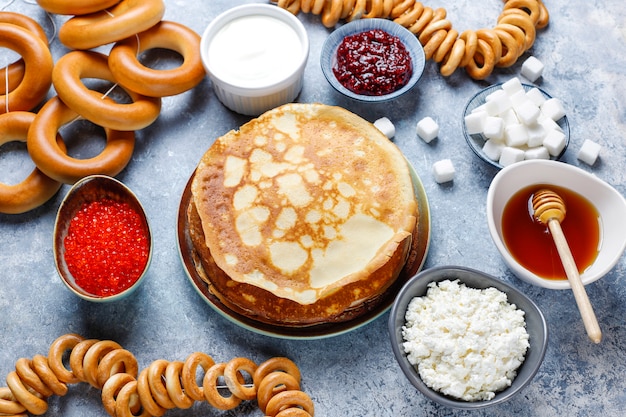 Russian pancake blini with raspberry jam, honey, fresh cream and red caviar, sugar cubes, cottage cheese, bubliks