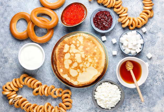 Russian pancake blini with raspberry jam, honey, fresh cream and red caviar, sugar cubes, cottage cheese, bubliks