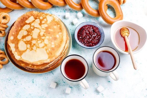 Russian pancake blini with raspberry jam, honey, fresh cream and red caviar, sugar cubes, cottage cheese, bubliks