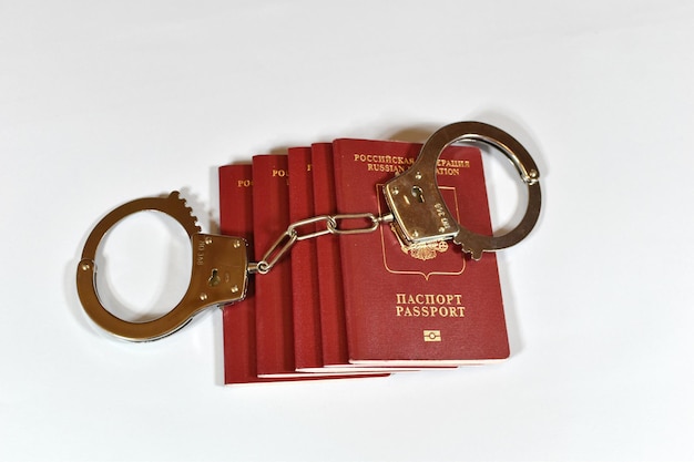 Russian passport and handcuffs on white background prohibition of Russian citizens on entry and exit passport lock