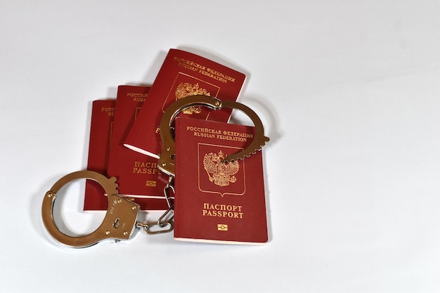 Russian passport and handcuffs on white background prohibition of Russian citizens on entry and exit passport lock