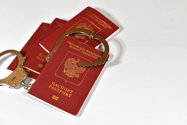 Russian passport and handcuffs on white background prohibition of Russian citizens on entry and exit passport lock