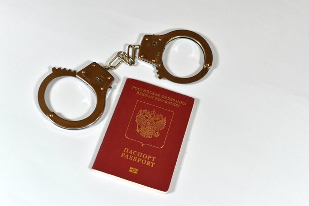 Russian passport and handcuffs on white background prohibition of Russian citizens on entry and exit passport lock