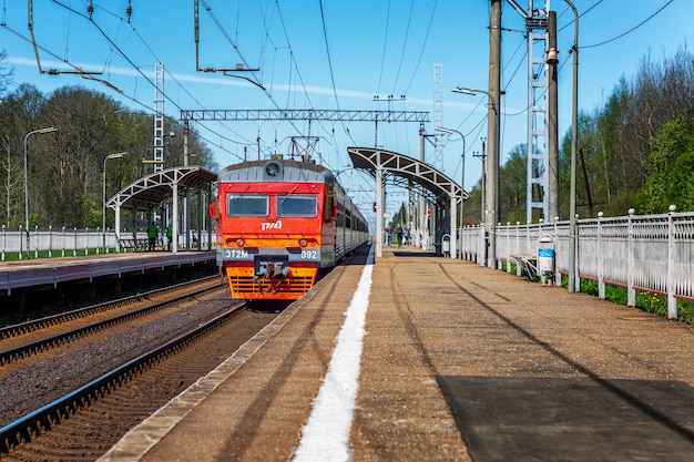 Russian Railways train departing from the platform at the provincial station on a clear sunny day.