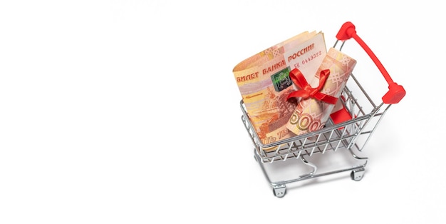 Russian roubles with red bow in toy trolly isolated on the white background. Discount or gift concept.