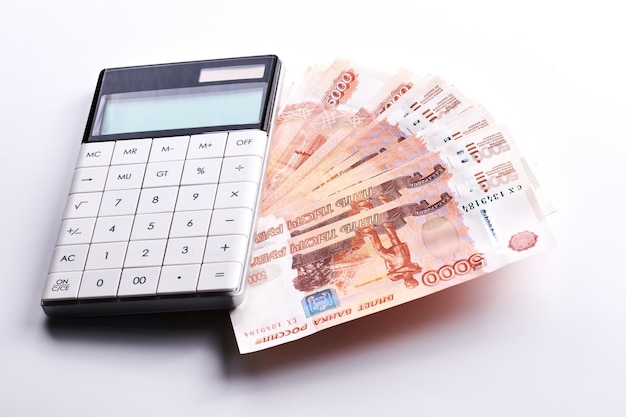 Russian rubles five thousandth banknotes calculator and stack of money on white background