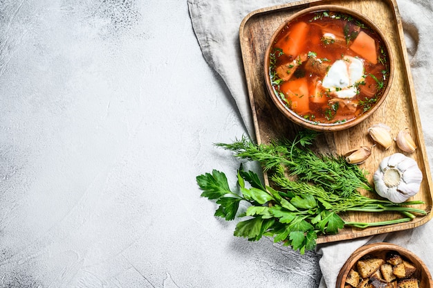 Russian speciality Borsch soup with beetrots and sour cream. Gray background. Top view. Space for text