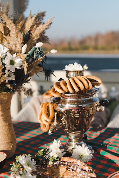 Russian Tea from Samovar. Winter tea party in nature. Pie with berries. samovar with bagels composition