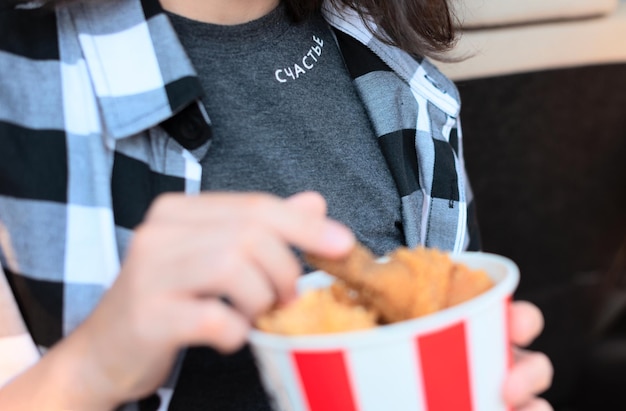 Russian word means Happiness close up with blurred fried chicken in the girl hands while watching a movie at drive in cinema Selective focus Entertainment leisure activities hobby concept