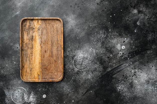 Rustic cutting board for food top view flat lay with copy space for text or your product on black dark stone table background