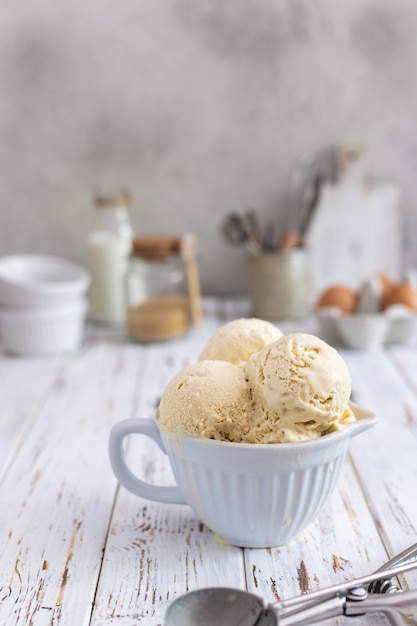 Rustic homemade ice cream in ceramic cup on white wooden table