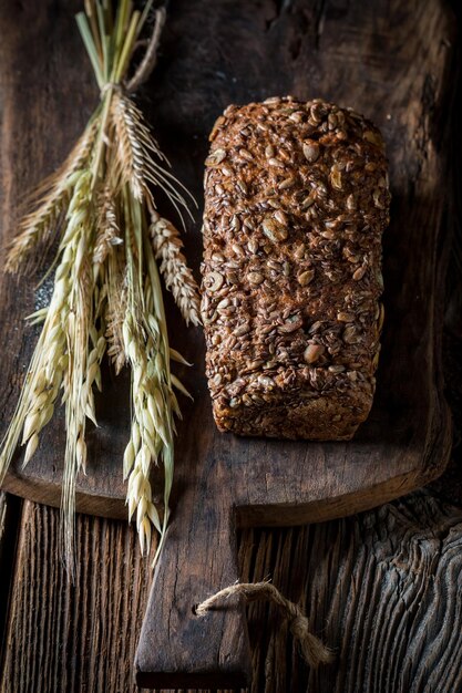 Rustic loaf of bread with grains with ears of wheat