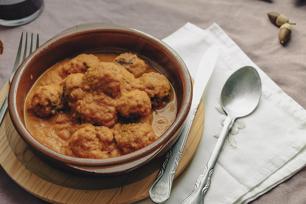 Rustic plate of meatballs in tomato sauce set on a tablecloth