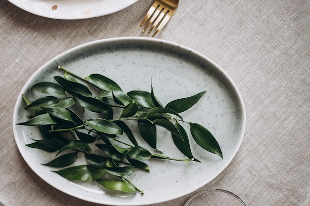 Rustic wedding table seting with vintage plates green and white eucalyptus garland gold utensils Boho style