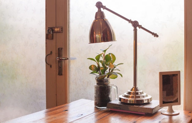 Rustic wooden reading room table with warm natural light setting illuminated through door glass window.