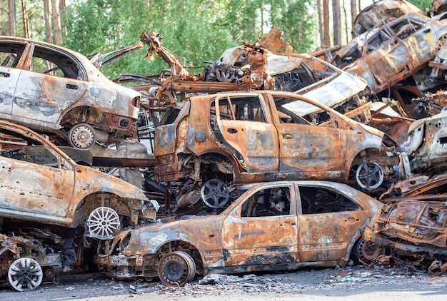 Rusty burnt cars destroyed by rocket explosions War in Ukraine Destroyed vehicles of civilians who