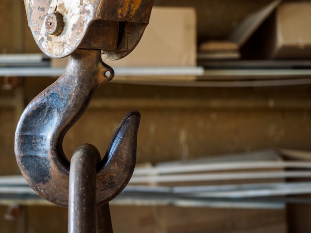 A rusty old hook from a crane in the factory.