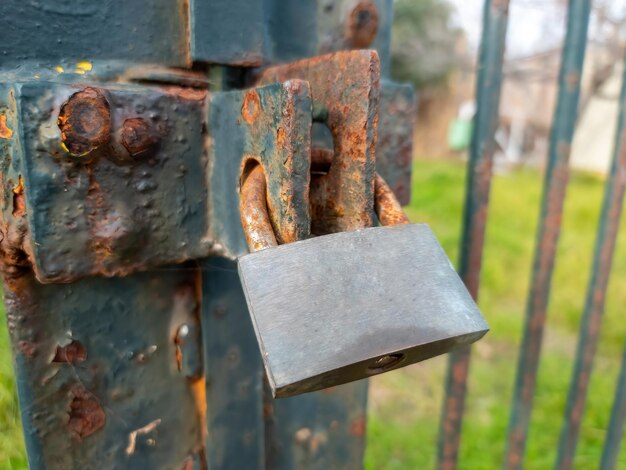 Rusty old padlock locked on gate of metal grid fence Entrance forbidden security safety