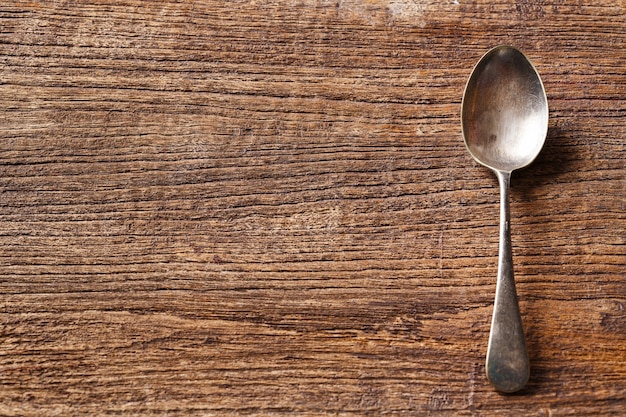 Rusty spoon on wooden table