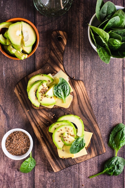 Rye bread bruschetta with avocado cheese spinach and flax seeds Healthy food Top and vertical