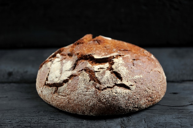 Rye bread, whole loaf on black rustic background