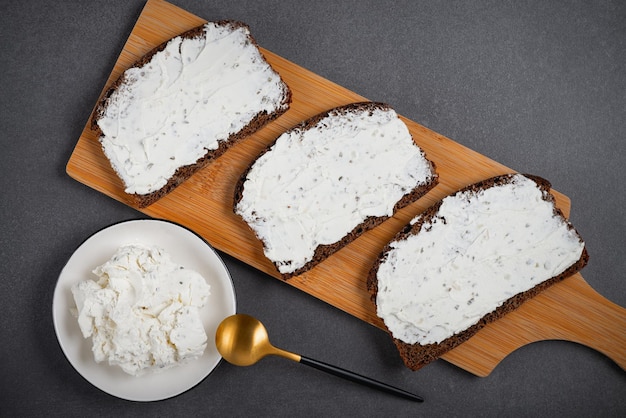 Rye bread with cream cheese on grey table