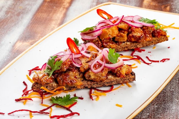 Rye croutons with veal brains and onions On a wooden background