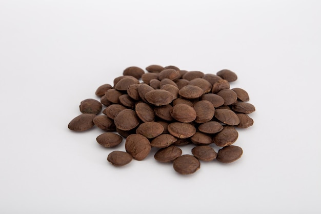 Sacha Inchi roasted seed nuts selective focus on front seeds on white background