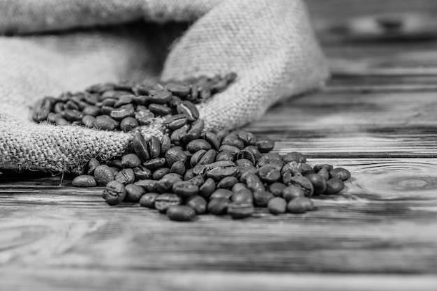 Sackcloth and scattered coffee beans on rustic wooden table