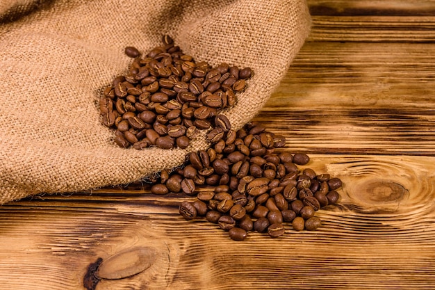 Sackcloth and scattered coffee beans on rustic wooden table