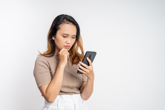 Sad asian young woman while using mobile phone