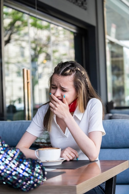 Sad blonde lady sitting at the restaurant and crying